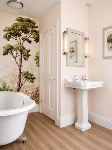 a bathroom with a white tub and a sink at Stylish Top Floor Retreat with Stunning Solent Views in Portsmouth
