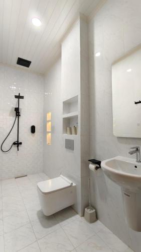 a white bathroom with a sink and a toilet at Villa Dalia Puncak EE11-24 in Cikujang