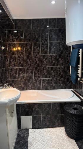 a bathroom with a bath tub and a sink at Vert Apartament in Tuzla