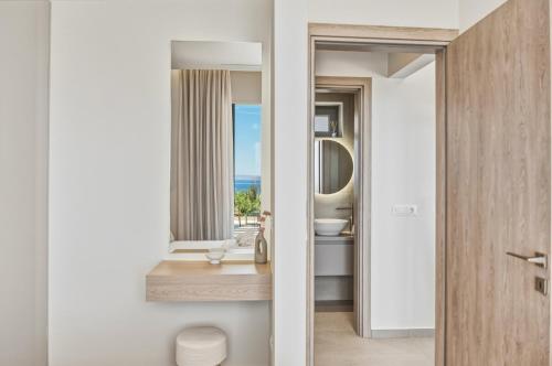 a bathroom with a sink and a mirror at Villa Elliopetra - Adults Only in Vasilikí