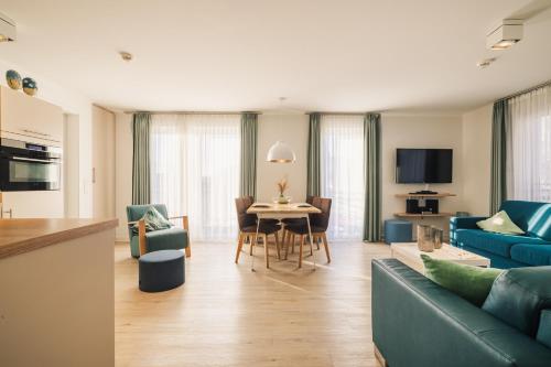 a living room with a blue couch and a table at Am Park 16 in Prerow