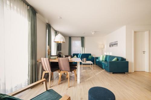a living room with a table and a dining room at Am Park 16 in Prerow