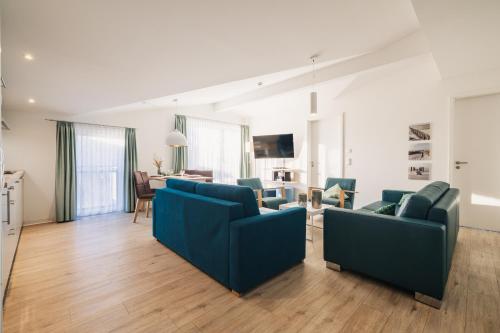 a living room with two blue couches at Am Park 25 in Prerow