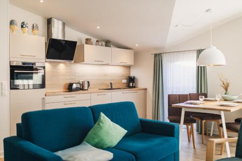 a living room with a blue couch and a table at Am Park 25 in Prerow