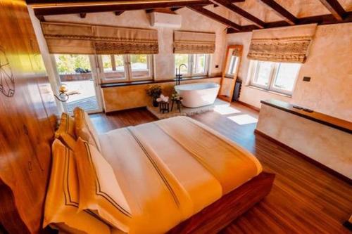 ein Schlafzimmer mit einem großen Bett und einer Badewanne in der Unterkunft Hotel Thethi in Theth