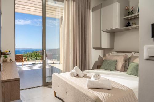 a bedroom with a bed and a view of the ocean at Villa Elliopetra - Adults Only in Vasilikí