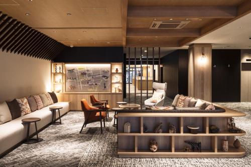 a living room with a couch and a table at Richmond Hotel Sapporo Odori in Sapporo