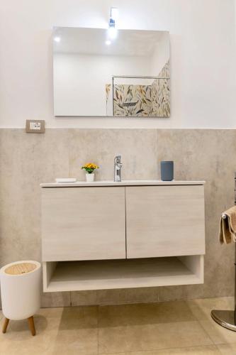 a bathroom with a white sink and a mirror at Gea Guest House in Syracuse