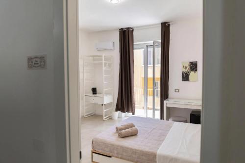 a bedroom with a bed and a desk and a window at Gea Guest House in Syracuse
