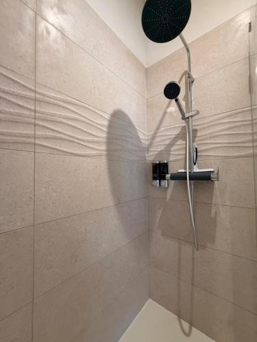 a shower with a shower head in a bathroom at Le Cocon du théâtre Clim Hyper centre in Orange