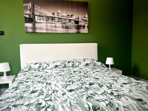 a bedroom with a bed with a green wall at Appartamento in centro storico "La Casa di Cri" in Asti