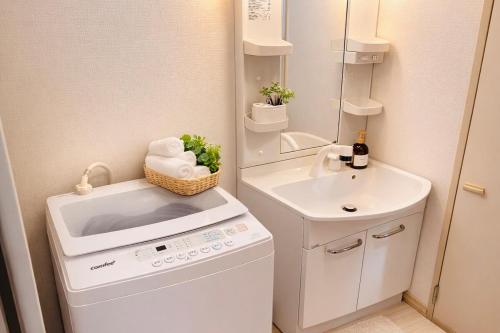 a small bathroom with a washing machine and a sink at Shonan Beach&Sun in Chigasaki