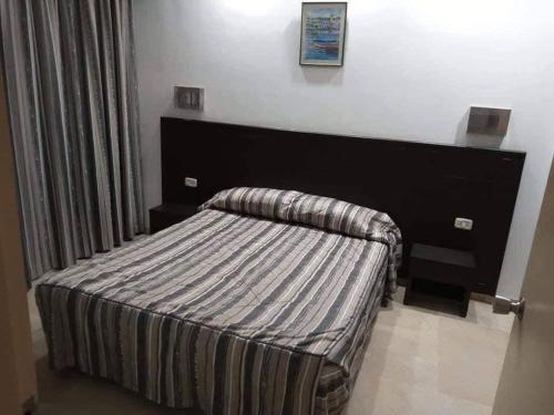 a bedroom with a bed in a room with avertisement at Appartement Hotel Andalucia Bizerte in Bizerte