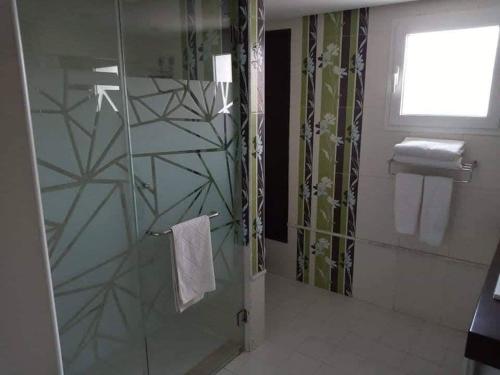 a bathroom with a shower with a glass door at Appartement Hotel Andalucia Bizerte in Bizerte