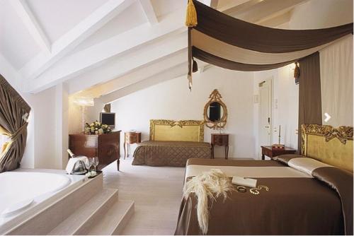 a large bedroom with two beds and a couch at M Glamour Hotel in Gabicce Mare