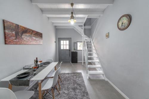 a white staircase in a white room with a table and chairs at Bursa Cottage House in Mesochórion