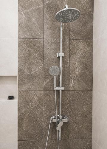 a shower with a glass door with a shower head at Djuragan Kamar Labuhan in Semarang