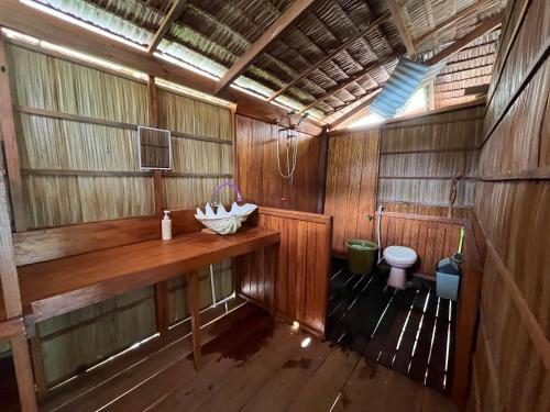 a wooden bathroom with a sink and a toilet at Kemmi Homestay Raja Ampat in Merpati