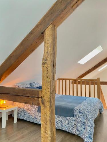 a bedroom with a wooden bed in a attic at Le secret du Morvan in Saulieu