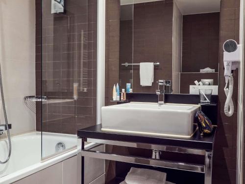 a bathroom with a white sink and a shower at Aparthotel Adagio Marseille Timone in Marseille