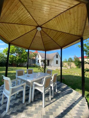 a table and chairs under a large wooden umbrella at Praqa House in Lankaran