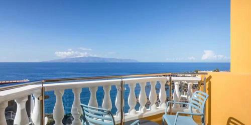a balcony with chairs and a view of the ocean at Servatur Isora Suites in Puerto de Santiago