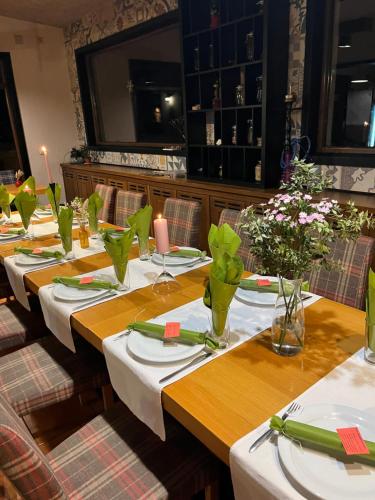 a set of tables in a restaurant with flowers on them at Trigrad Hotel in Trigrad