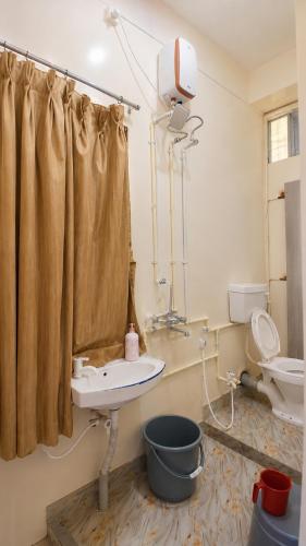a bathroom with a sink and a toilet at Thaanya Guest Rooms in Chinchwad