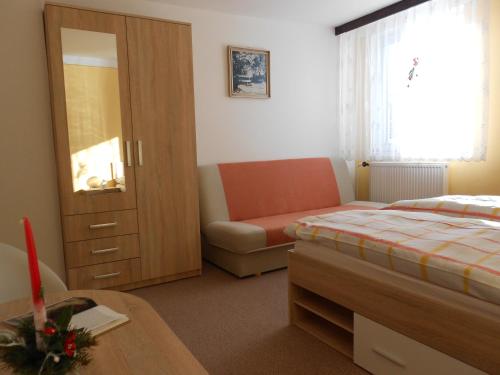 a bedroom with a bed and a couch and a table at Ubytování - Žáková in Vrbno pod Pradědem