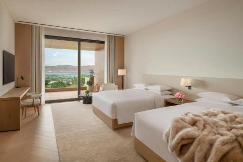 a hotel room with two beds and a large window at The Dali EDITION in Dali