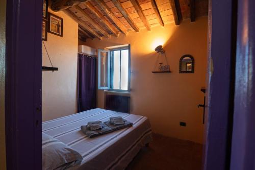 a bedroom with a bed and a window with a pair of shoes at NIDO SCANSANESE in Scansano
