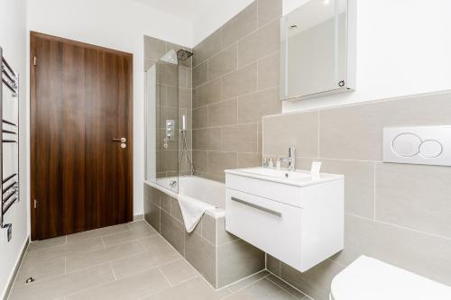 Ibis House by Viridian Apartments في ريتشموند: حمام مع حوض ومرحاض وحوض استحمام