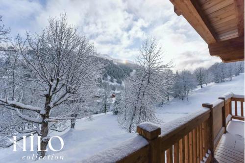 a snow covered balcony with a view of a snowy mountain at Chalet Alya by HILO Collection in Les Allues