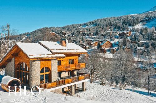 a log cabin in the snow with a mountain at Chalet Alya by HILO Collection in Les Allues