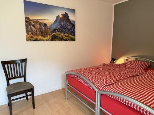 a bedroom with a bed and a chair and a picture on the wall at Revier schlicht und bahnsinnig in Mitlödi