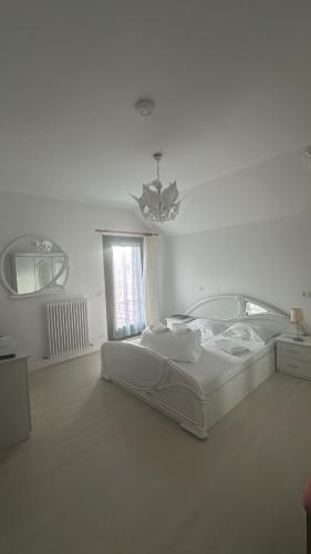 a white room with a bed and a mirror at Casa Salcia Oituz in Oituz