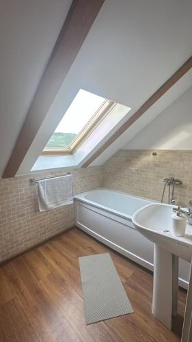 a bathroom with a bath tub and a sink at Casa Salcia Oituz in Oituz
