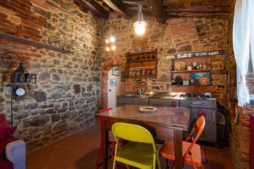 a kitchen with a wooden table and yellow chairs at NIDO SCANSANESE in Scansano