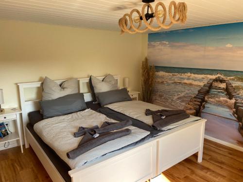 a bedroom with a bed with a painting of the ocean at Ferienhaus am Wald - Leipzig Land Whirlpool & Infrarotkabine in Brandis
