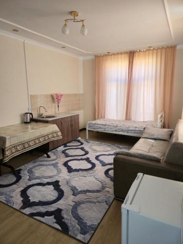 a living room with a couch and a table at Гостевой дом "Greenway Tourist" in Bosteri
