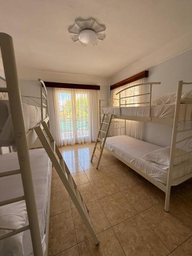 a room with four bunk beds and a window at Amphitrite's Paradise Apartments in Olympic Beach
