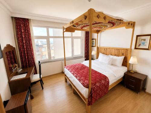 a bedroom with a canopy bed and a window at Marmara Guesthouse in Istanbul