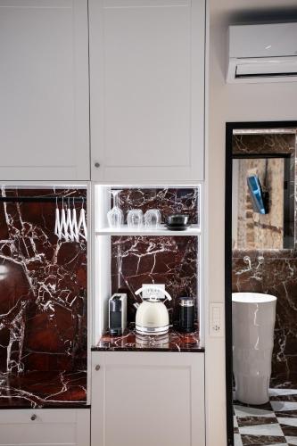 a kitchen with white cabinets and a counter top at Nalia Suites in Nafplio