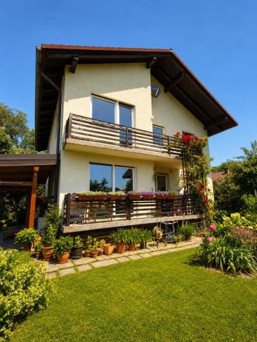 a house with a balcony with flowers and plants at Apartma Tanja bike-friendly in Limbuš