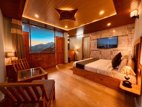 a bedroom with a bed and a large window at The Sana Cottge, Manali - Affordable Luxury Stay in Manali in Manāli