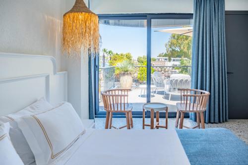 a bedroom with a bed and chairs and a patio at Casa Colore Boutique House in Bodrum City