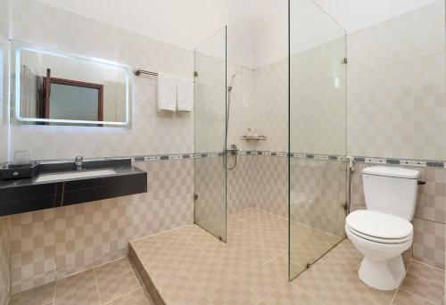 a bathroom with a toilet and a glass shower at Grand Center Da Lat by Lilly Hotel in Da Lat
