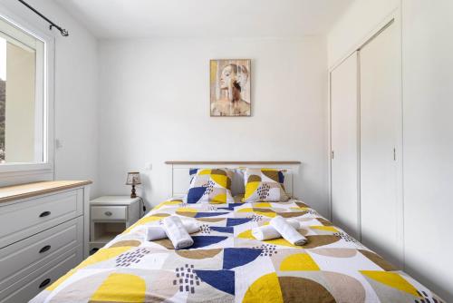 a bedroom with a bed with a colorful quilt at L'interlude in Amélie-les-Bains-Palalda