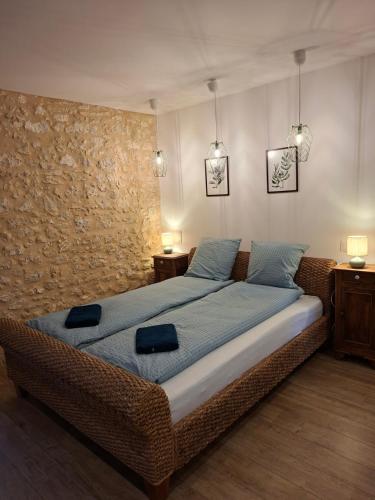 a bedroom with a large bed with blue sheets and two lamps at Les Marchettes in Saint-Nexans