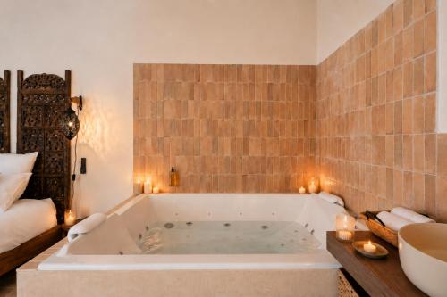 a bathroom with a large tub with candles in it at La Cour Secrète - Riad & Balnéo privée in Carpentras